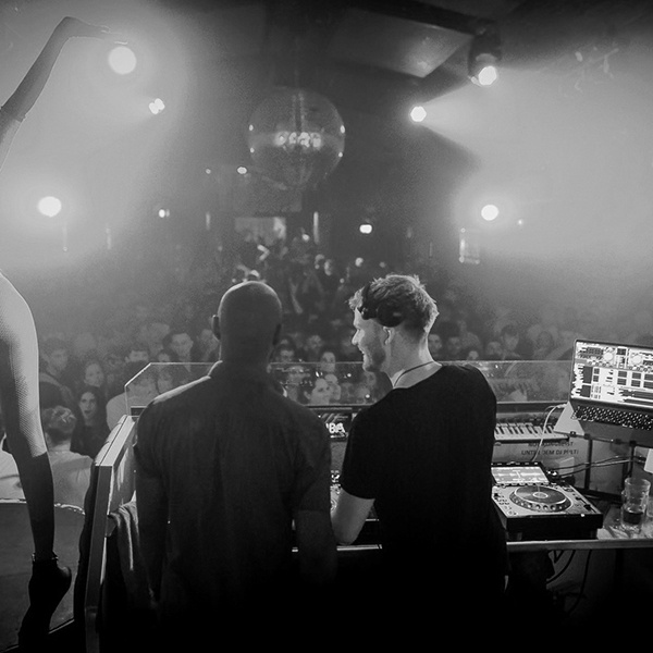 Michael Avenue energizing the crowd with a dynamic DJ set in a popular club.